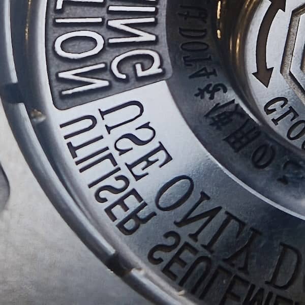 Zbliżenie laserowego graweru z napisami wykonanymi na powierzchni formy wtryskowej